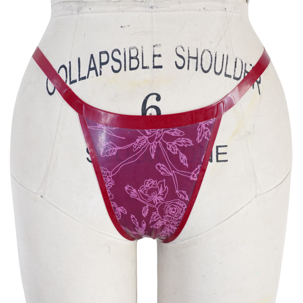A mannequin torso displays a maroon floral thong with thin red straps from Vex Clothing, INC against an off-white background. A "Ready to Ship" banner appears, with black printed text and numbers on the mannequin.